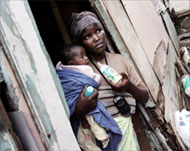 Nosibusiso Tocholo, 23, holds her two-month-old baby outside her shack in one of Durban's slums