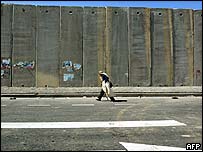A Palestinian man walks past the Israeli barrier near Jerusalem